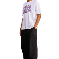 Modello che indossa la t-shirt “First Kiss” con stampa bubblegum sul davanti, visto di lato