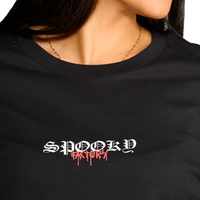 dettaglio della T-shirt nera con stampa sul retro di satiri che ballano indossata dalla modella.